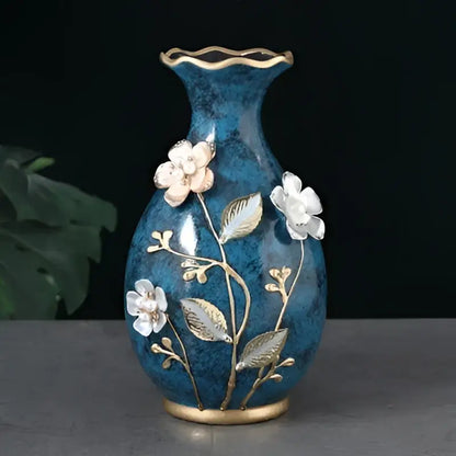 Deep blue ceramic vase with gold-trimmed rim and base, white floral appliqués, ideal for dried flowers display