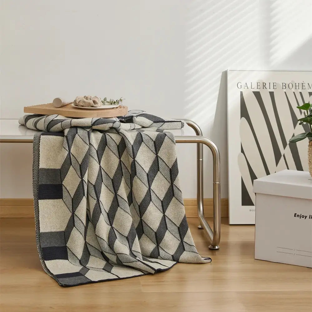 A cozy cube cotton knitted plaid blanket in black gray and cream with a geometric diamond pattern for bedroom decor