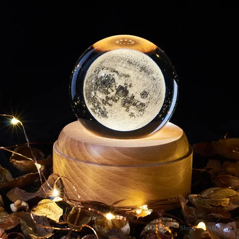 A decorbites crystal ball night light featuring a glowing transparent lunar sphere on a wooden music box base