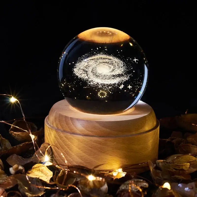 A 3d galaxy crystal ball night light on a warm wooden base featuring intricate galaxy design decorbites crystal ball