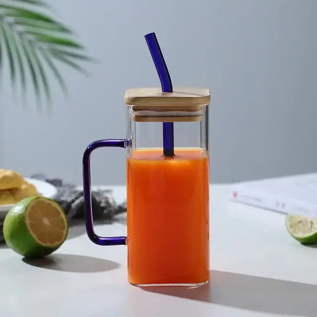Clear glass 400ml square glass mug with purple handle and lid filled with orange juice and blue straw for dining room use