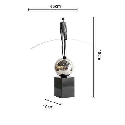 A sleek black metal human figure sculpture balancing on a silver sphere for living room decorbites decor