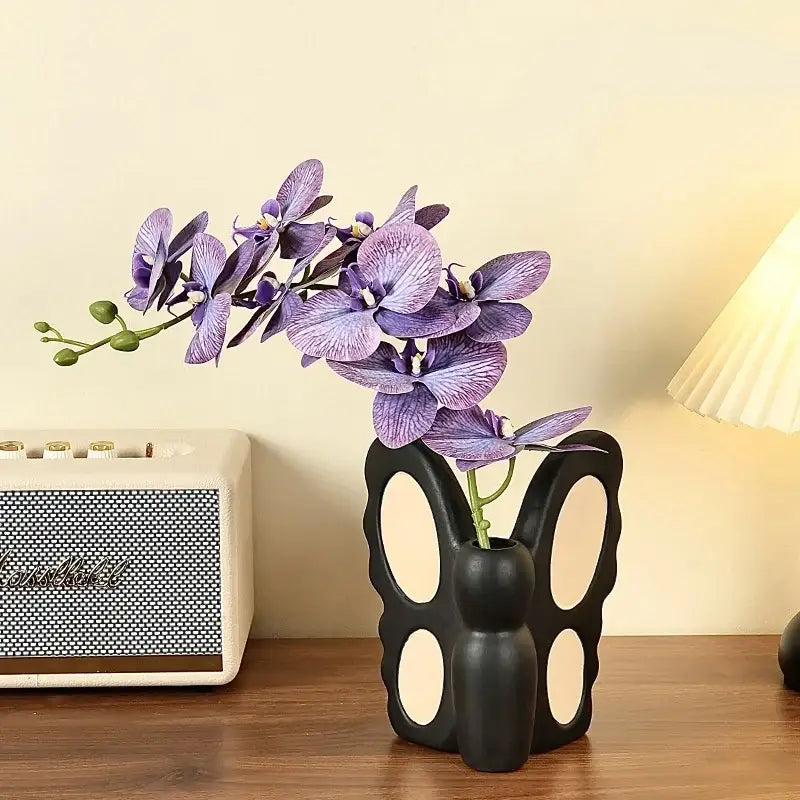 Abstract black butterfly ceramic vase holding purple orchids as decorbites black butterfly living room bunny decor