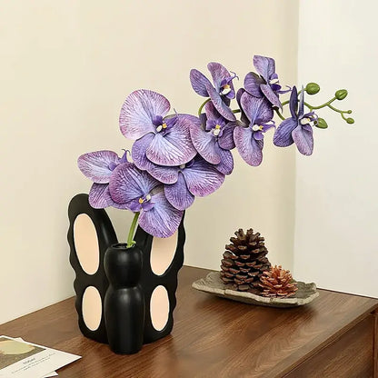 Black butterfly ceramic vase shaped like a black bunny with cream cutouts holding purple orchid for living room decorbites black butterfly decor