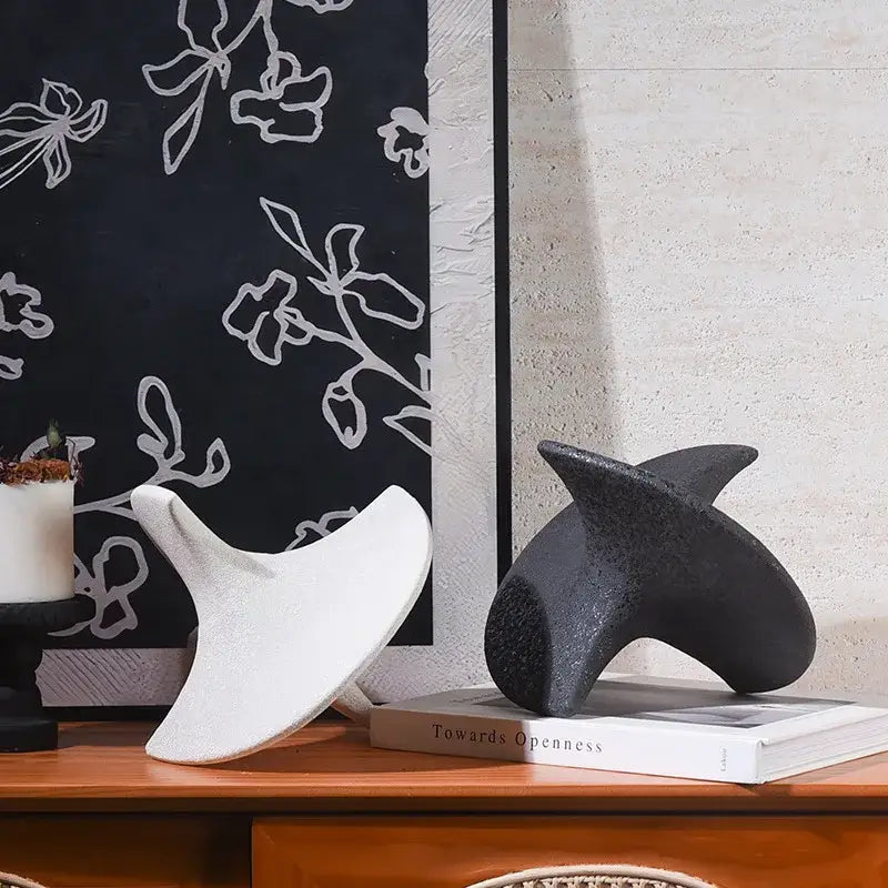White and black abstract ceramic gyroscope ornaments with smooth flowing forms for geometric ceramic decor