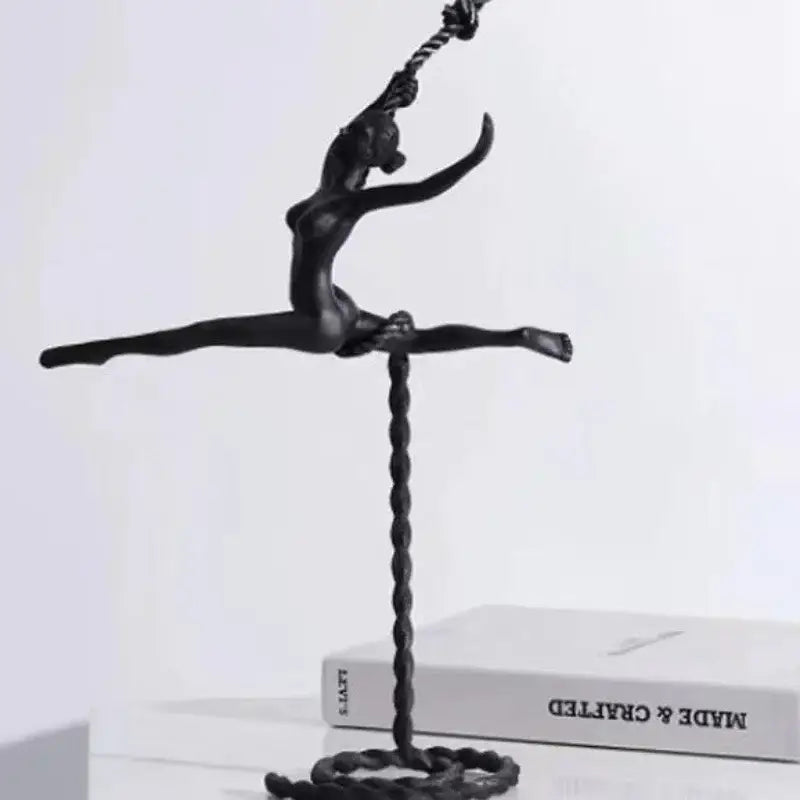 Abstract black metal ballerina dancer sculpture in mid-air split pose with twisted rope base for living room decor