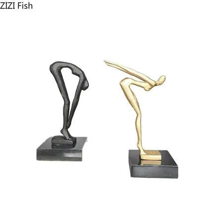 Two abstract black metal gymnast statue desk ornaments in matte black and gold finish on black bases for decorbites decor