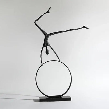 Abstract black metal sports figure sculpture by decorbites featuring a stylized human balancing on a circular ring