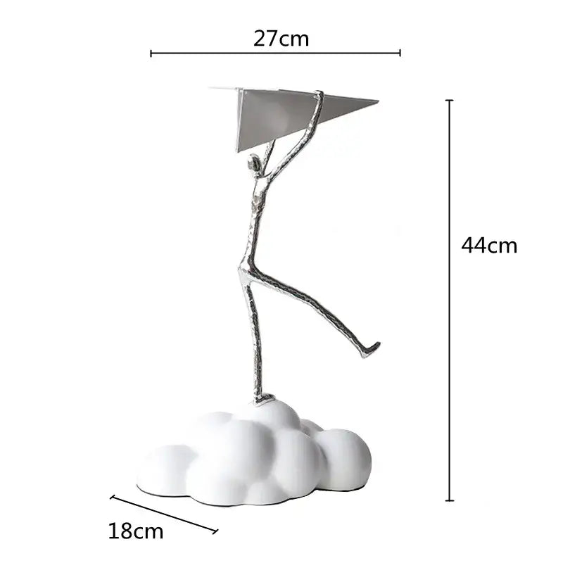Silver metallic figurine holding a triangular resin paper airplane on a white cloud base for living room decor