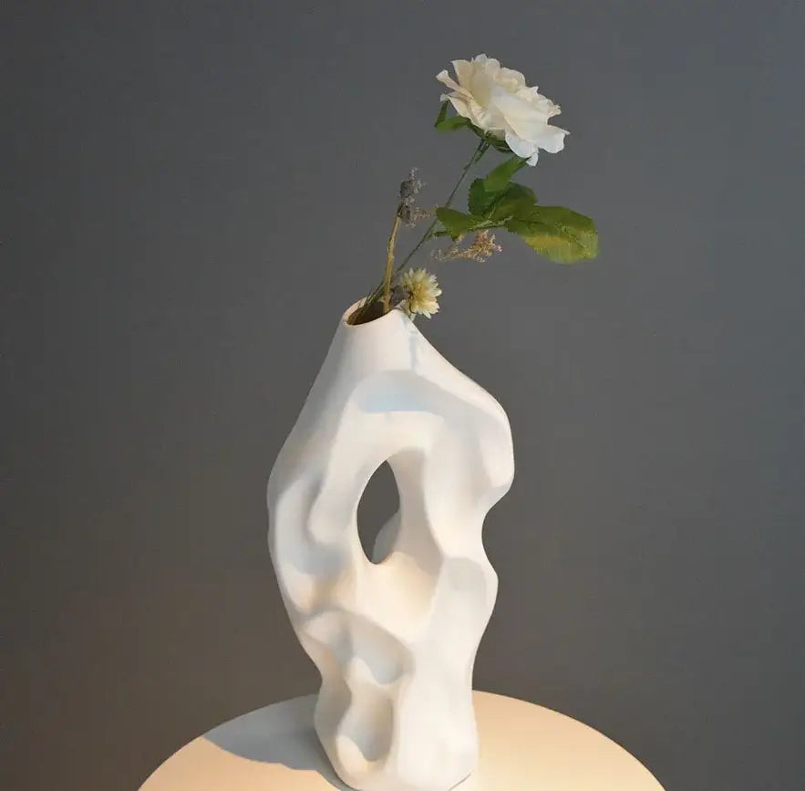 White abstract ceramic vase with organic flowing contours and central oval opening for living room decorbites black decor