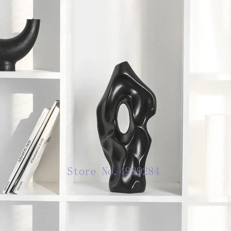 Black glossy abstract ceramic vase with organic flowing contours and central oval opening for living room decorbites decor