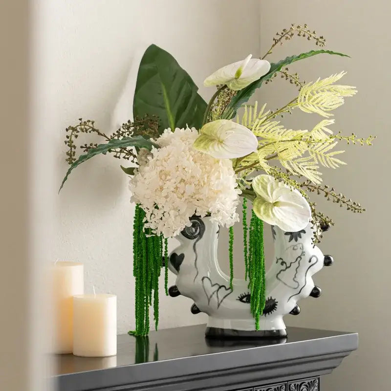 White ceramic graffiti ceramic vase with black abstract patterns and green beaded drapes for living room decorbites decor