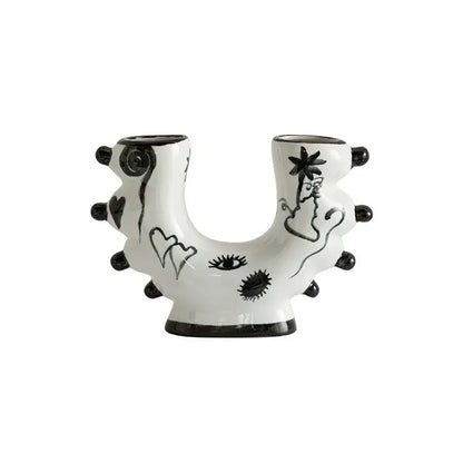 White ceramic u-shaped decorbites graffiti ceramic vase with black hand-painted eyes hearts and palm tree illustrations