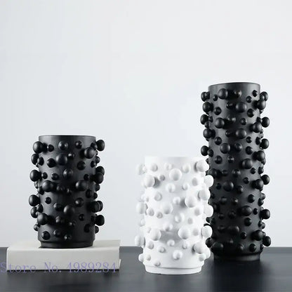 Three cylindrical resin vases in black white with irregular bumps for decorbites black white abstract living room decor