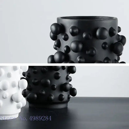 Black ceramic vase with irregular bumps and textured surface featuring black white abstract decorbites style design