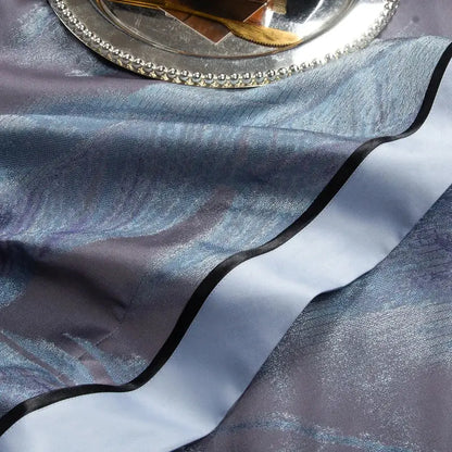 A shimmering blue satin table runner with black trim complements the abstract blue and gray 1500tc jacquard egyptian cotton bedding set