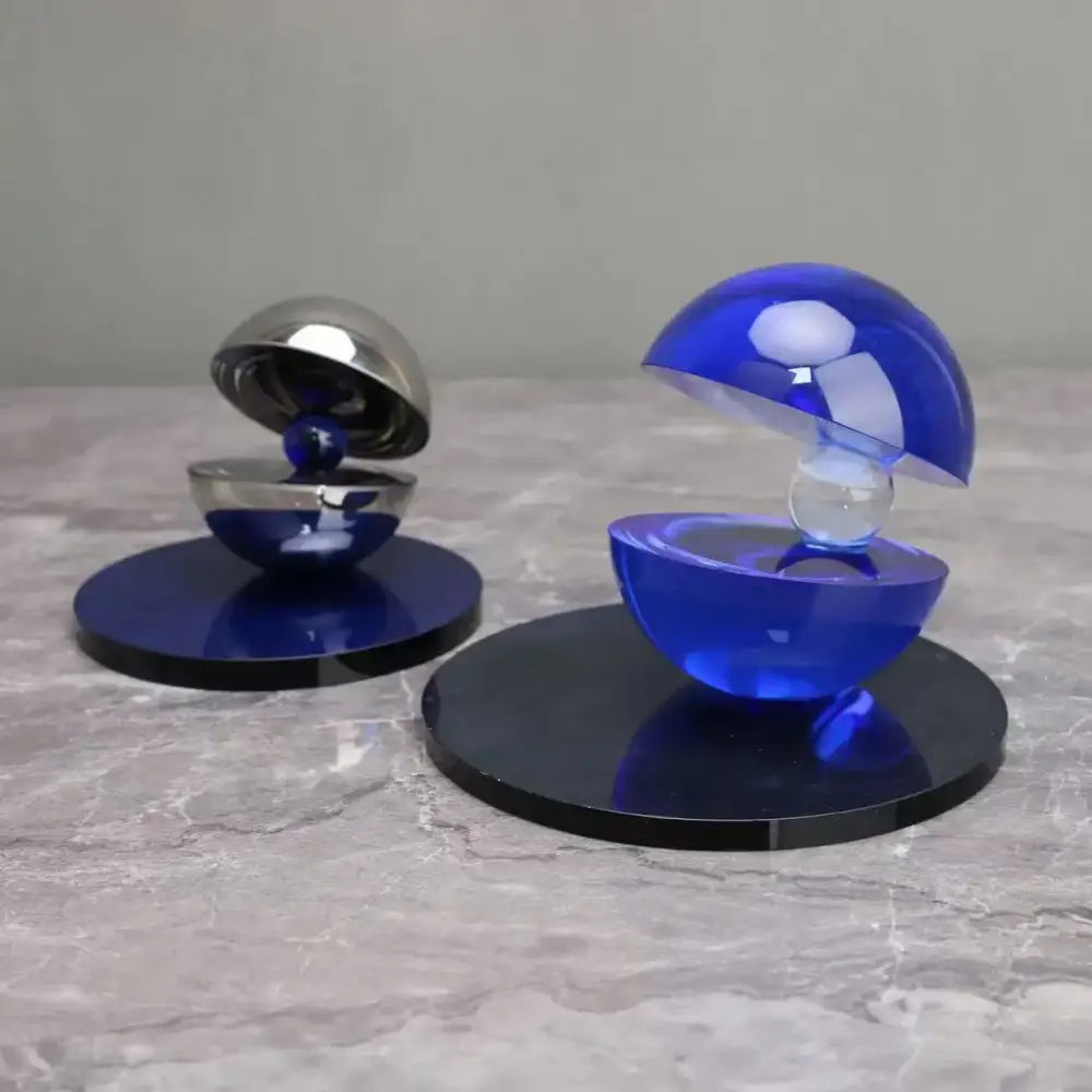 Blue and silver spherical semi-circle ornaments with reflective glossy surfaces on black bases for home decor decorbites crystal glass