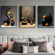 Set of three DecorBites™ abstract canvas prints with black and gold geometric forms and orange spheres above a bed