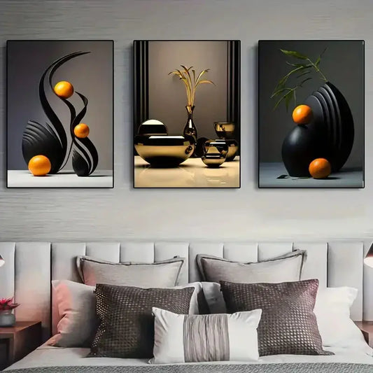 Set of three DecorBites™ abstract canvas prints with black and gold geometric forms and orange spheres above a bed