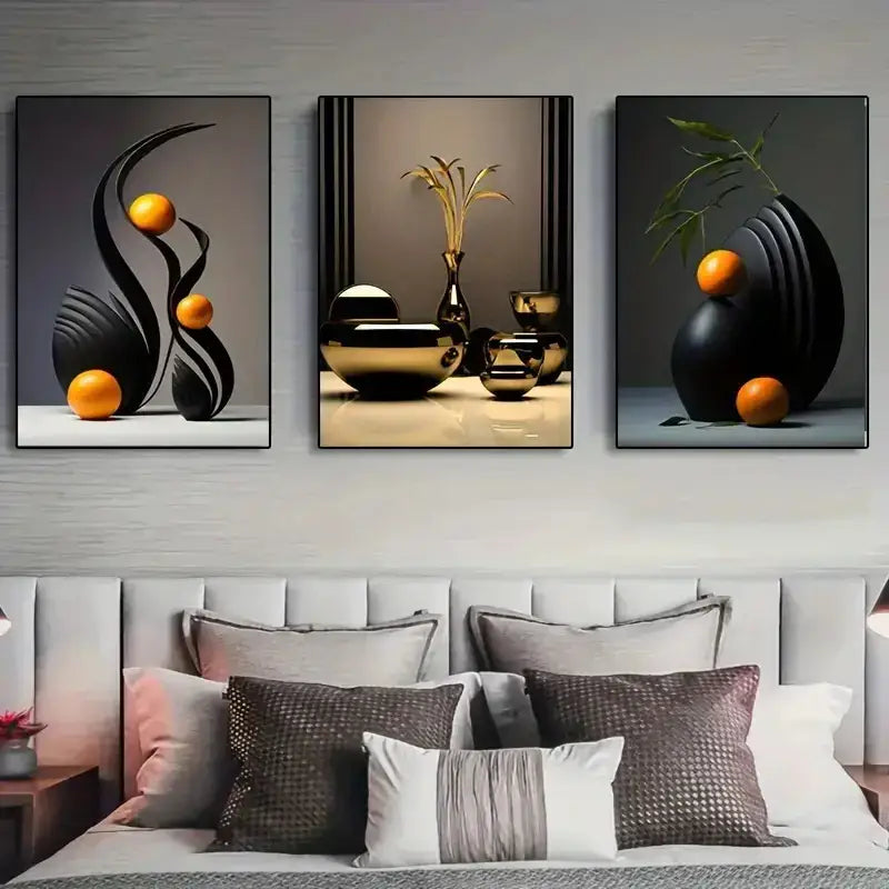 Set of three DecorBites™ abstract canvas prints with black and gold geometric forms and orange spheres above a bed