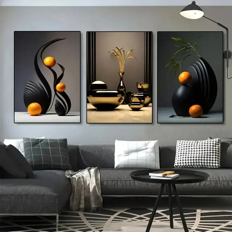 Set of three decorbites™ abstract canvas prints featuring black and gold geometric forms with orange spheres above sofa