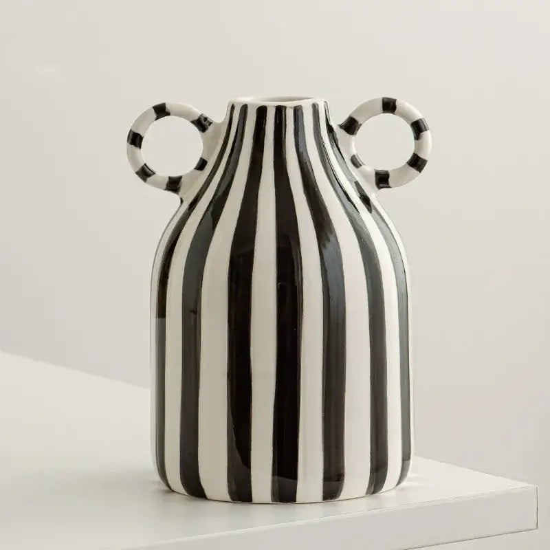 A sleek abstract ceramic hydroponic vase in black and white with double ear handles and vertical stripes