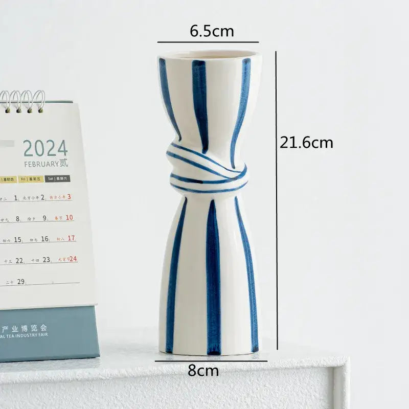 Abstract ceramic hydroponic vase in white ceramic with bold blue stripes and knotted design measuring 21.6cm tall