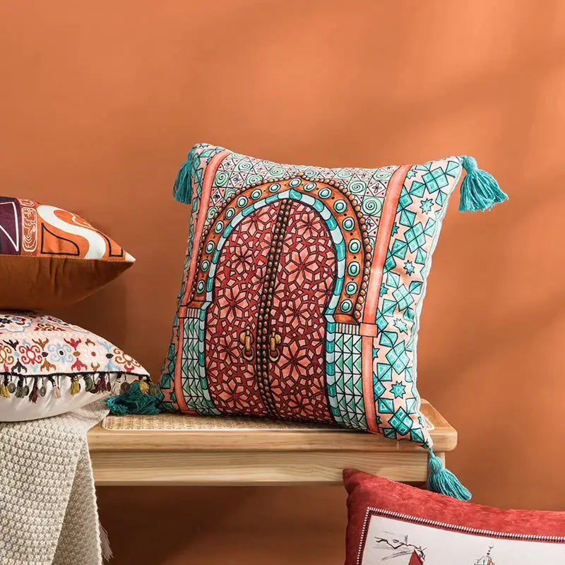 Vibrant abstract geometric cushion cover coral and teal with intricate arched doorway design and decorative tassels decorbites