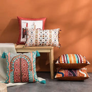 A vibrant coral and teal decorbites abstract geometric cushion cover with detailed archway design and matching tassels