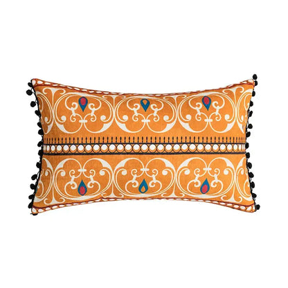Orange and blue decorbites abstract geometric printed cushion cover with white ornate patterns and black pom-pom trim