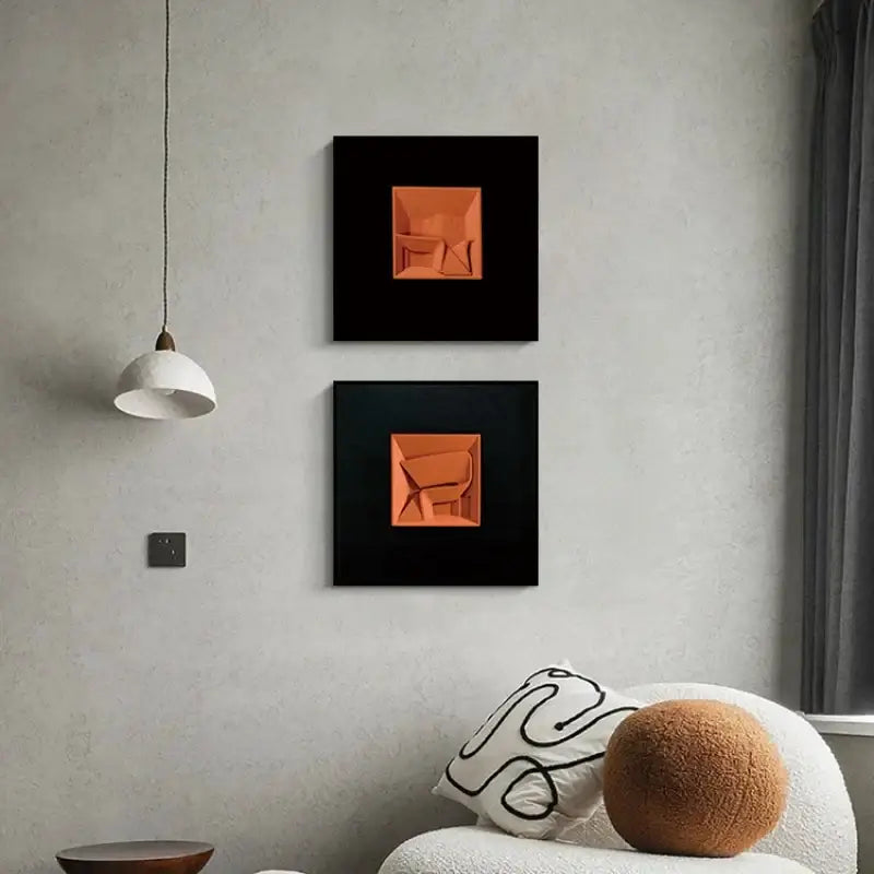 Two square-framed decorbites abstract geometric wall decoration featuring vibrant orange 3d forms on black background