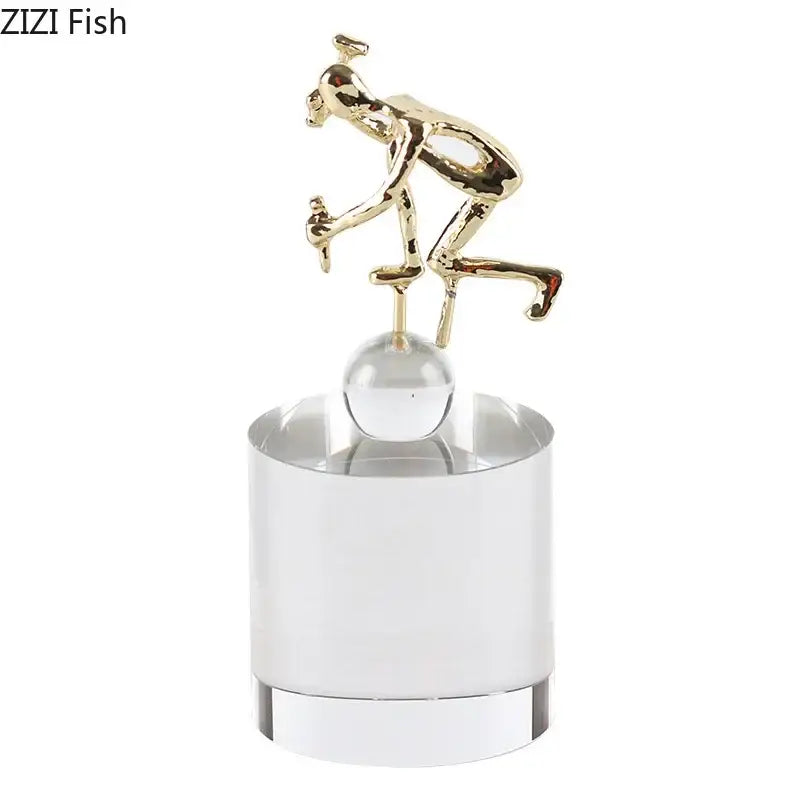 Abstract gold intertwined figures desk decor featuring a gold cyclist figurine on a clear decorbites crystal sculpture base