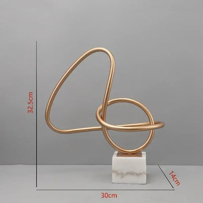 Gold-toned decorbites gold line geometric metal sculpture with intertwined loops on white marble base for living room decor