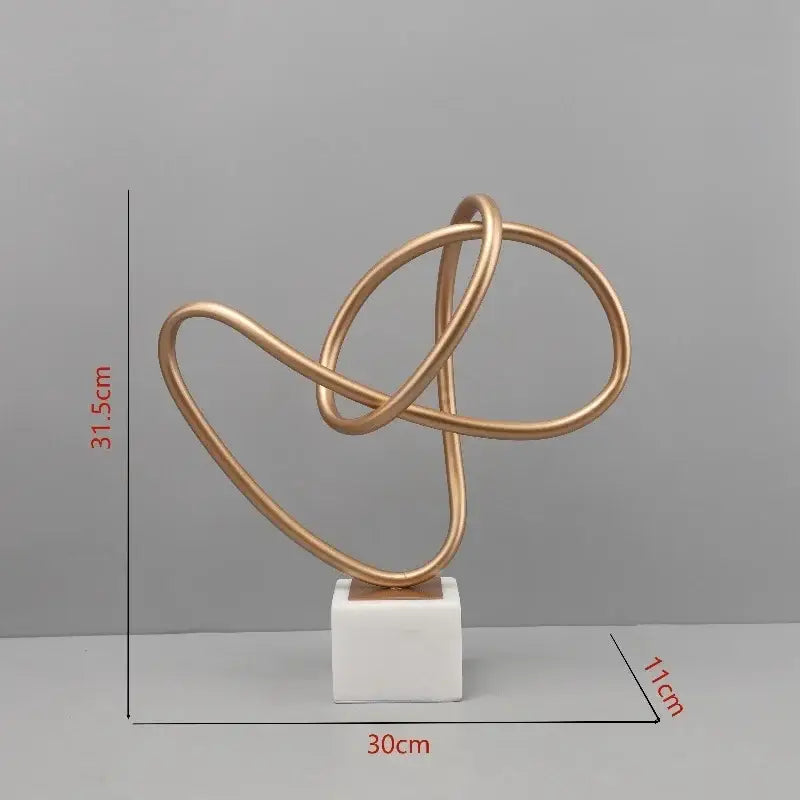 Abstract gold line geometric metal sculpture with interlocking loops on white marble base for living room decorbites decor