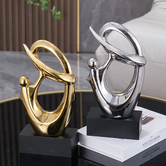 Two abstract decorative figurines in polished gold and mirrored silver on black bases for living room decorbites golden geometric art