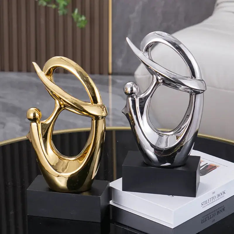 Two abstract decorative figurines in polished gold and mirrored silver on black bases for living room decorbites golden geometric art
