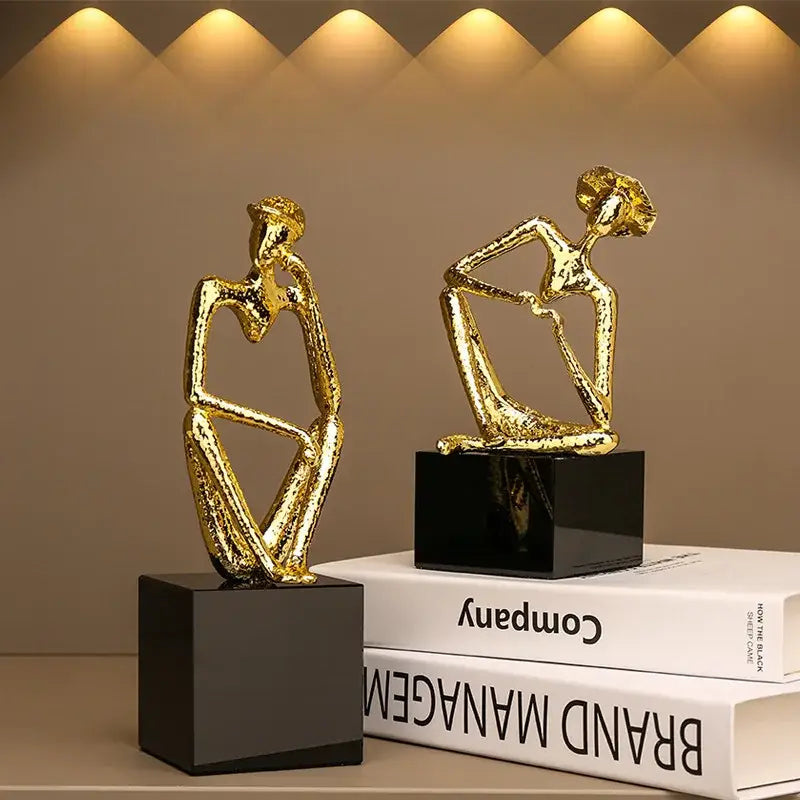 Abstract golden hat thinker figure with textured surfaces seated on black square bases for living room decorbites decor