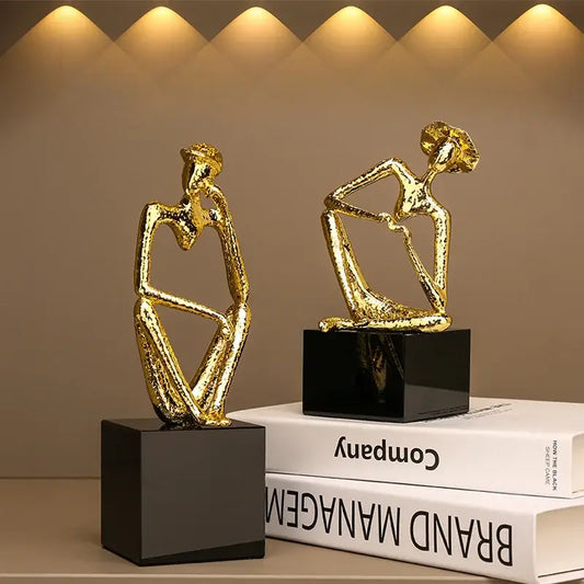 Abstract golden hat thinker figure with textured surfaces seated on black square bases for living room decorbites decor
