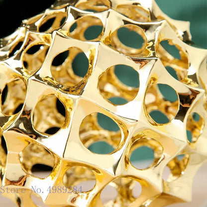 Abstract golden metal hollow ball spike ornament with faceted honeycomb design for living room decor