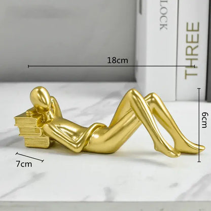 Golden metallic minimalist figurine of a thinker reader man reclining with books for living room decor