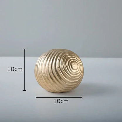 A 10cm diameter golden wave ball sculpture with concentric textured ridges for living room metal decor
