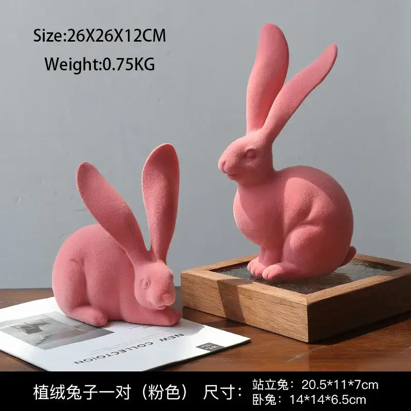 A pair of soft pink plush rabbit figurines with velvety fabric complementing abstract rabbit resin decor art