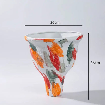 A 36cm tall abstract irregular ceramic vase set with flared shape and bold orange red green brushstrokes on white base decorbites