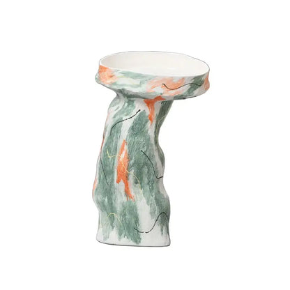 A ceramic pedestal bowl with an abstract irregular pattern in green and orange hues for living room decor