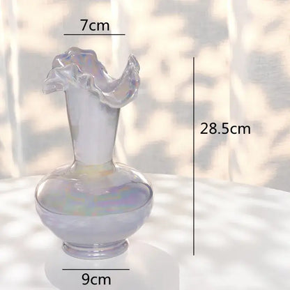 A translucent iridescent glass vase with a fluted ruffled rim and rounded base for decorbites ceramic shell decor