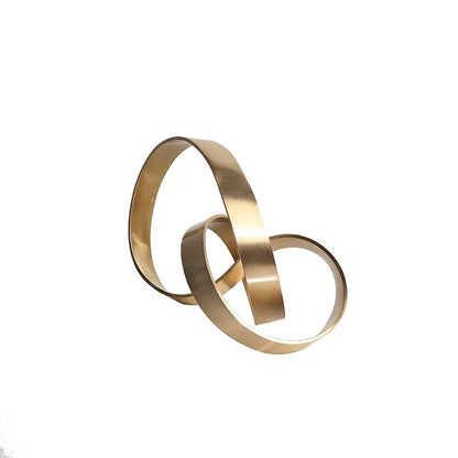 Abstract knot golden metal sculpture featuring gold-toned metallic rings interlocked in minimalist living room decor