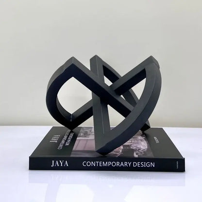 Black ornament abstract geometric sculpture with matte finish and interlocking loops for abstract home decoration