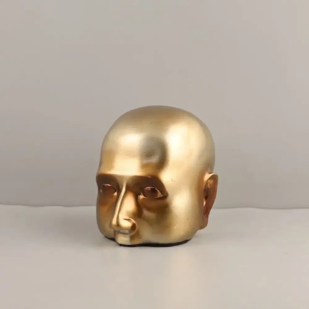 Golden metallic head half sculpture with smooth reflective surface and minimalist features for home decor by decorbites