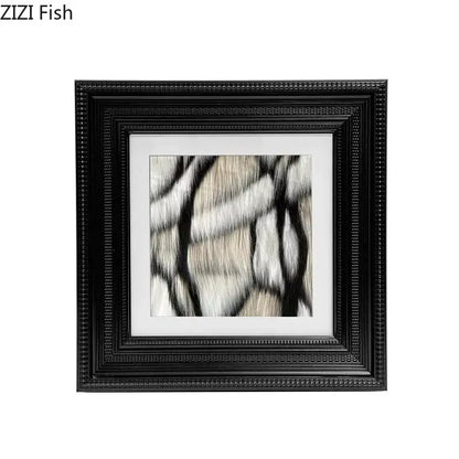 Black ornate picture frame with beaded border enclosing decorbites abstract modern wall art in beige and black brushstrokes