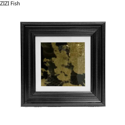 Black ornate picture frame with white mat holding abstract modern wall art featuring gold and black textured patterns decorbites abstract modern